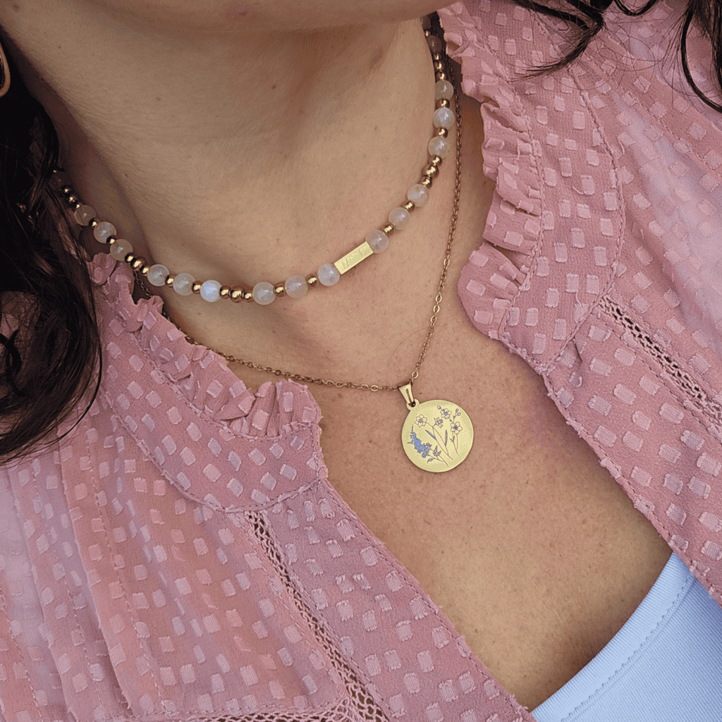 Elegante parelketting en gouden medaillon ketting met bloemenmotivatie.